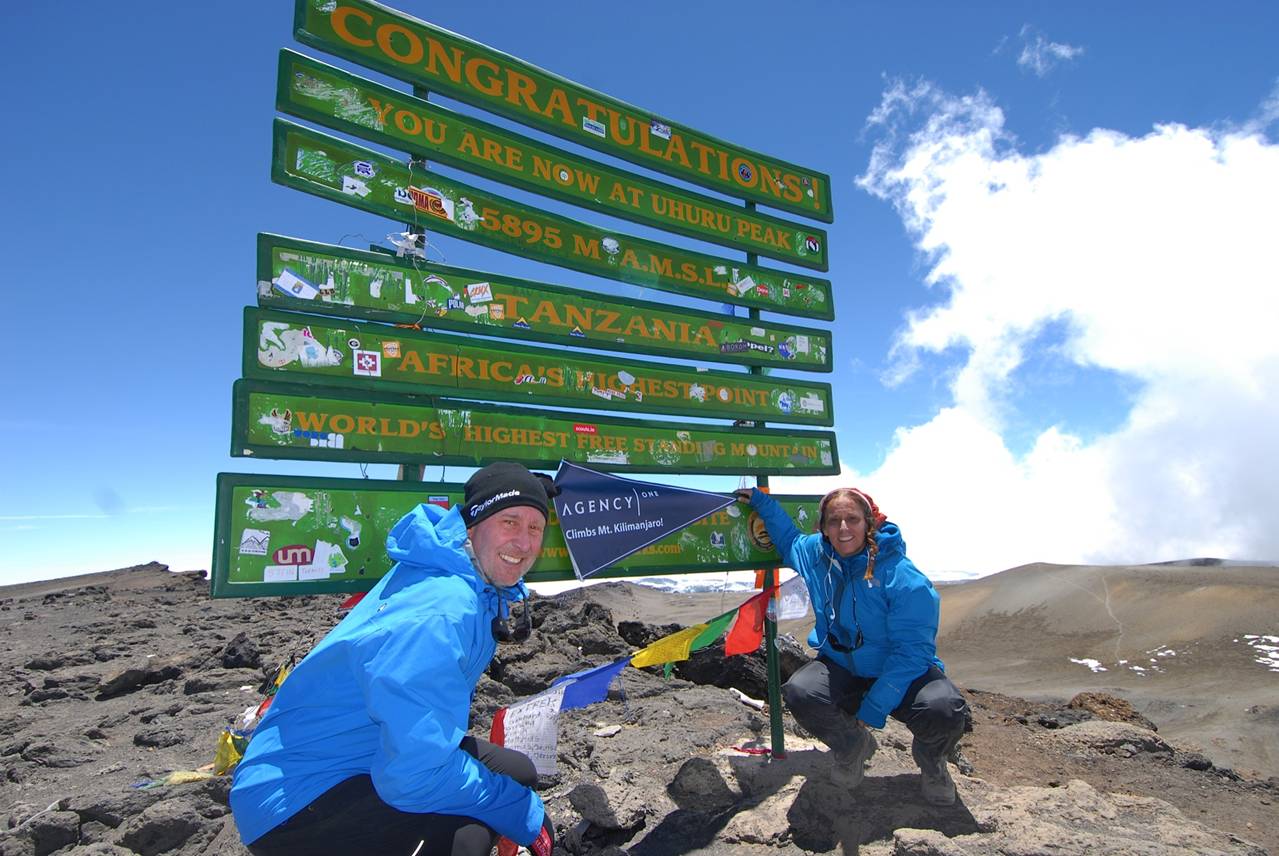 Underwriting Mountain Climbers - Ed Leisher & Cathy Neifeld at the Mt. Kilimanjaro sign