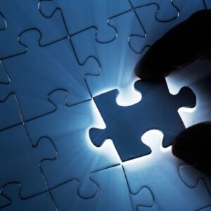 a silhouetted hand placing a puzzle piece within a puzzle signifying a strategically chosen product